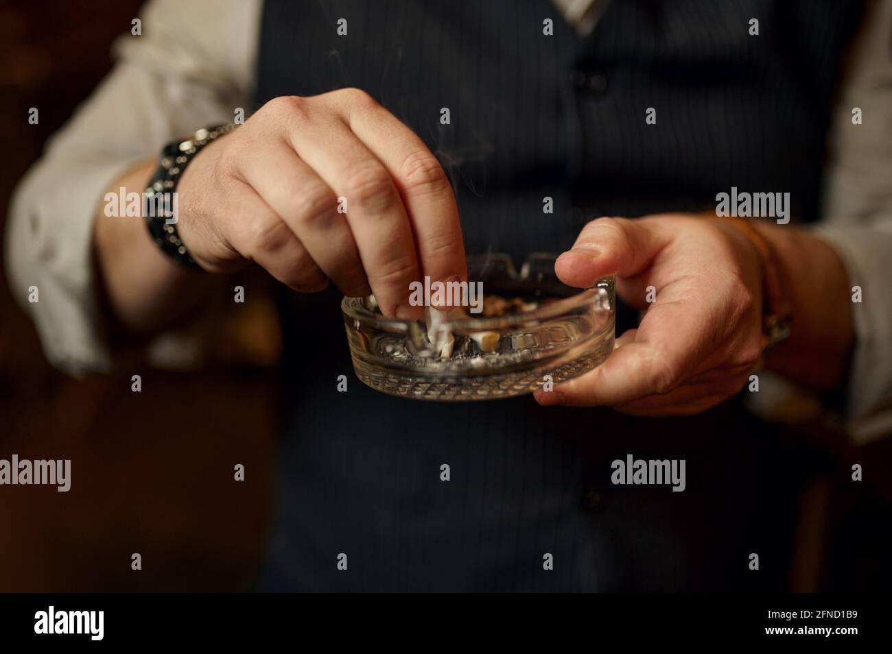 Man puts out a cigarette in ashtray, closeup view Stock Photo Alamy