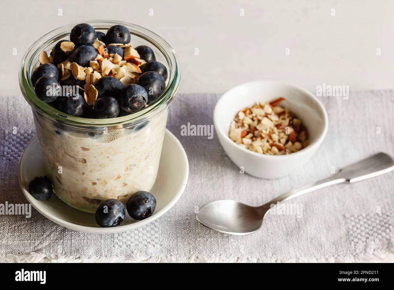 Glass of porridge with blueberries on wooden table Stock Photo