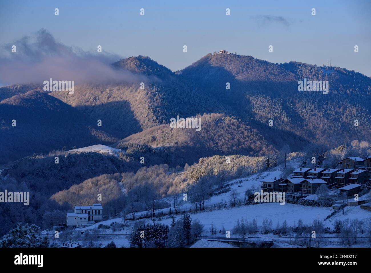 Snowy sunrise over the town and valley of Molló, seen from La Ginestosa. In the background, the Serra Cavallera (Ripollès, Catalonia, Spain, Pyrenees) Stock Photo
