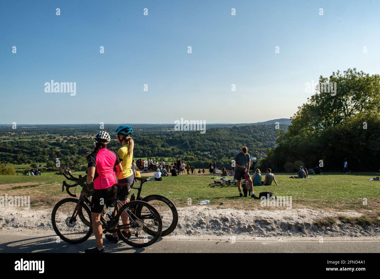 Two femal cyclists enjoy the views from Boxhill in Surrey in late summer - a popular tourist attraction Stock Photo
