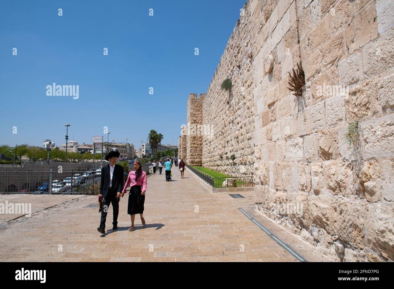 A young Jewish couple walking nearby Jerusalem's Old City walls near Jaffa Gate. Stock Photo