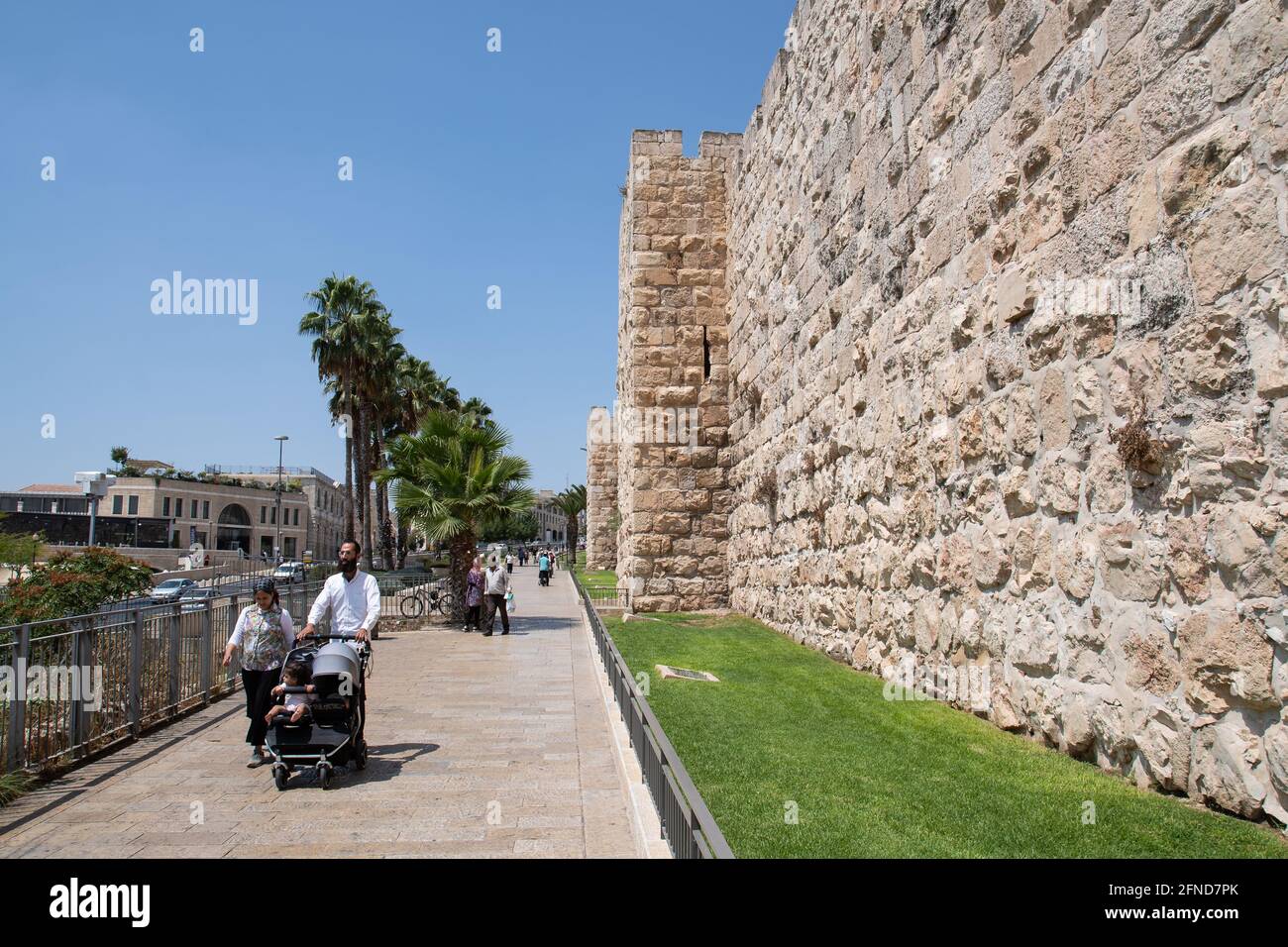 People walking nearby Jerusalem's Old City walls near Jaffa Gate. Stock Photo