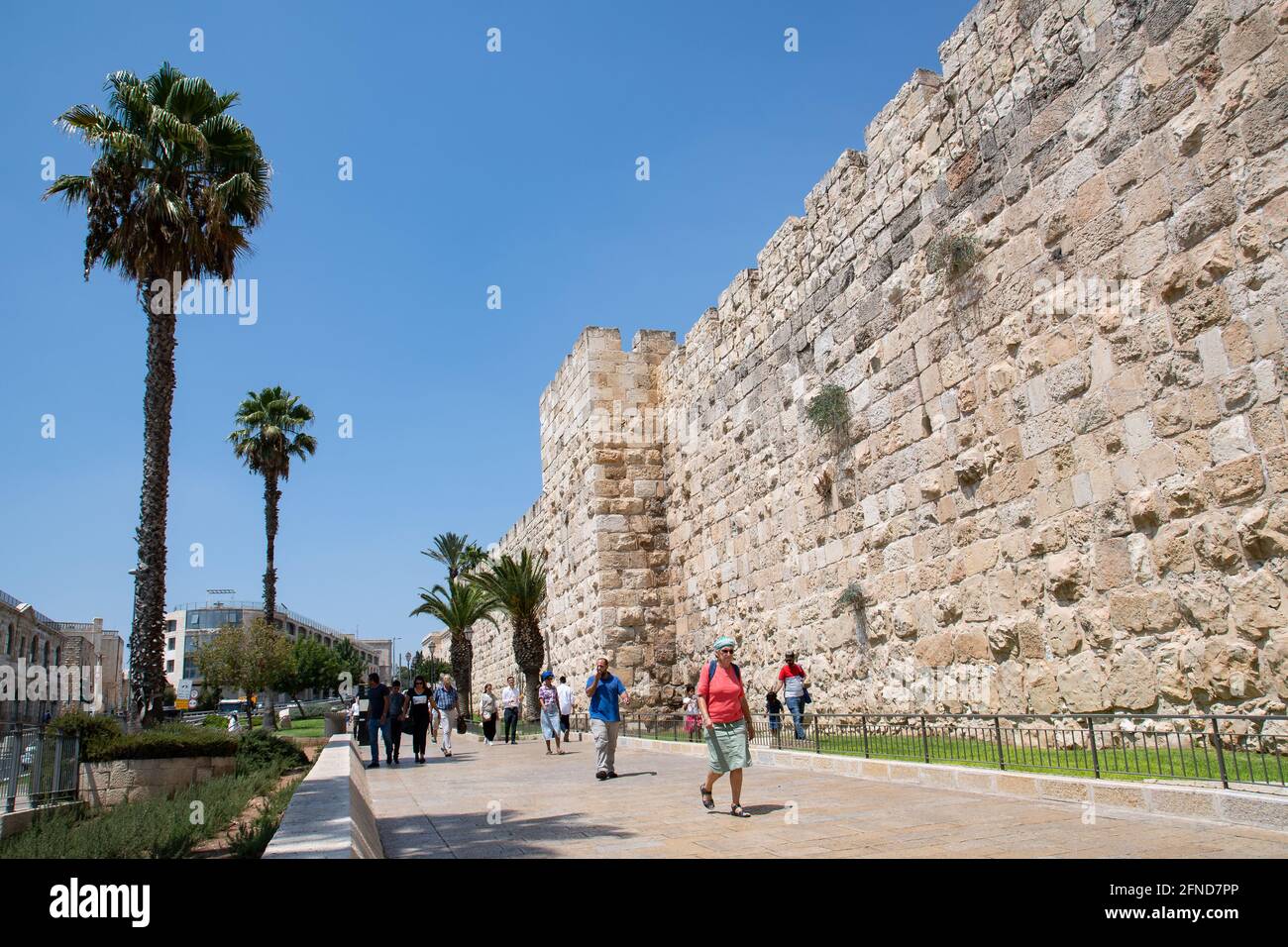 Tourists walking nearby Jerusalem's Old City walls. Stock Photo