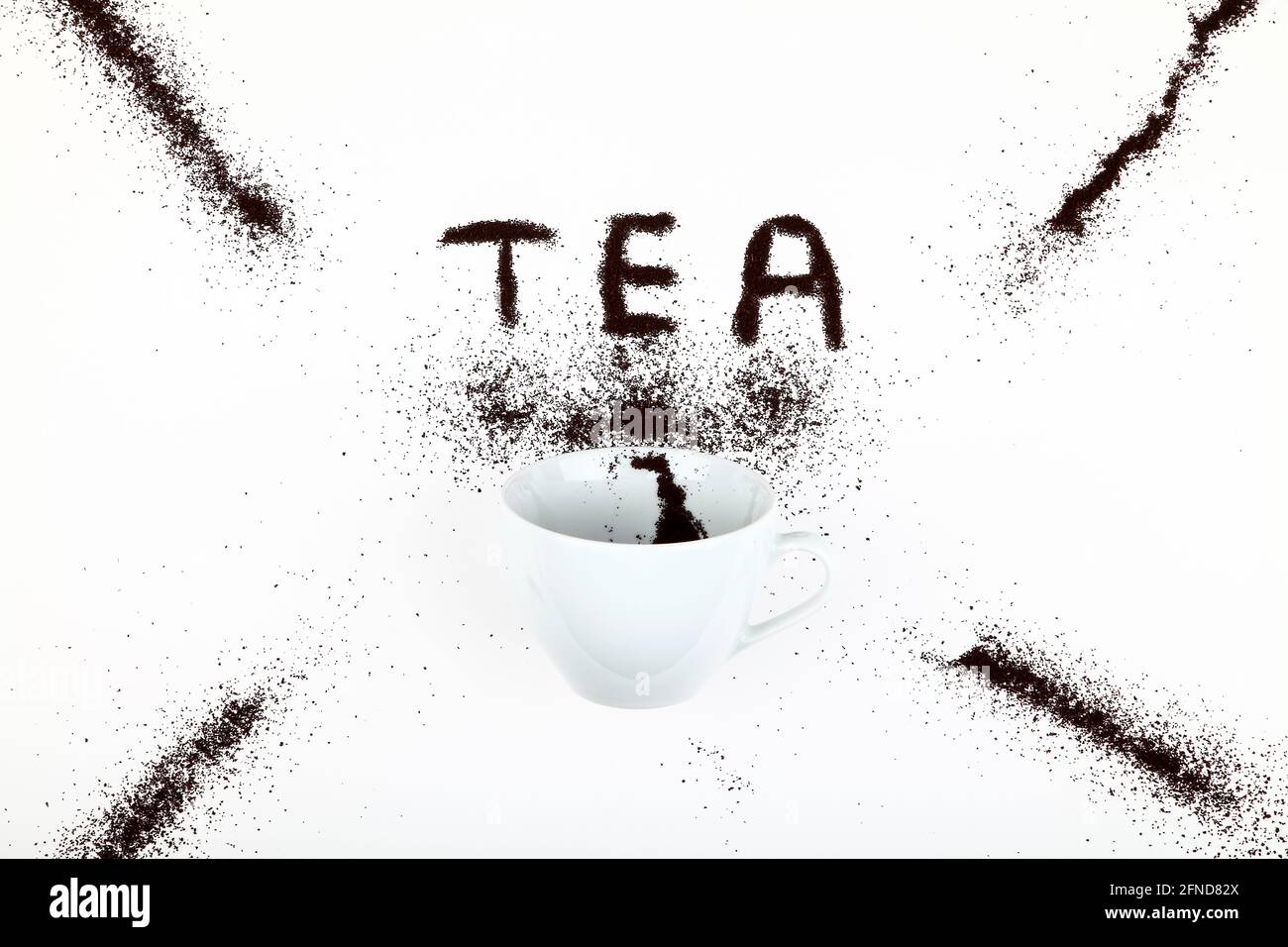 Tea cup with tea leaves spilling out creating the word tea Stock Photo