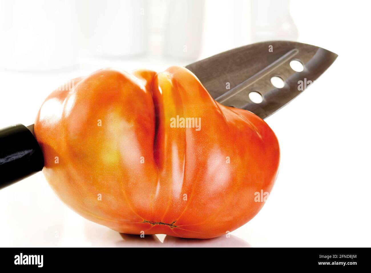 Close up of Oxheart Tomato and knife on white background Stock Photo