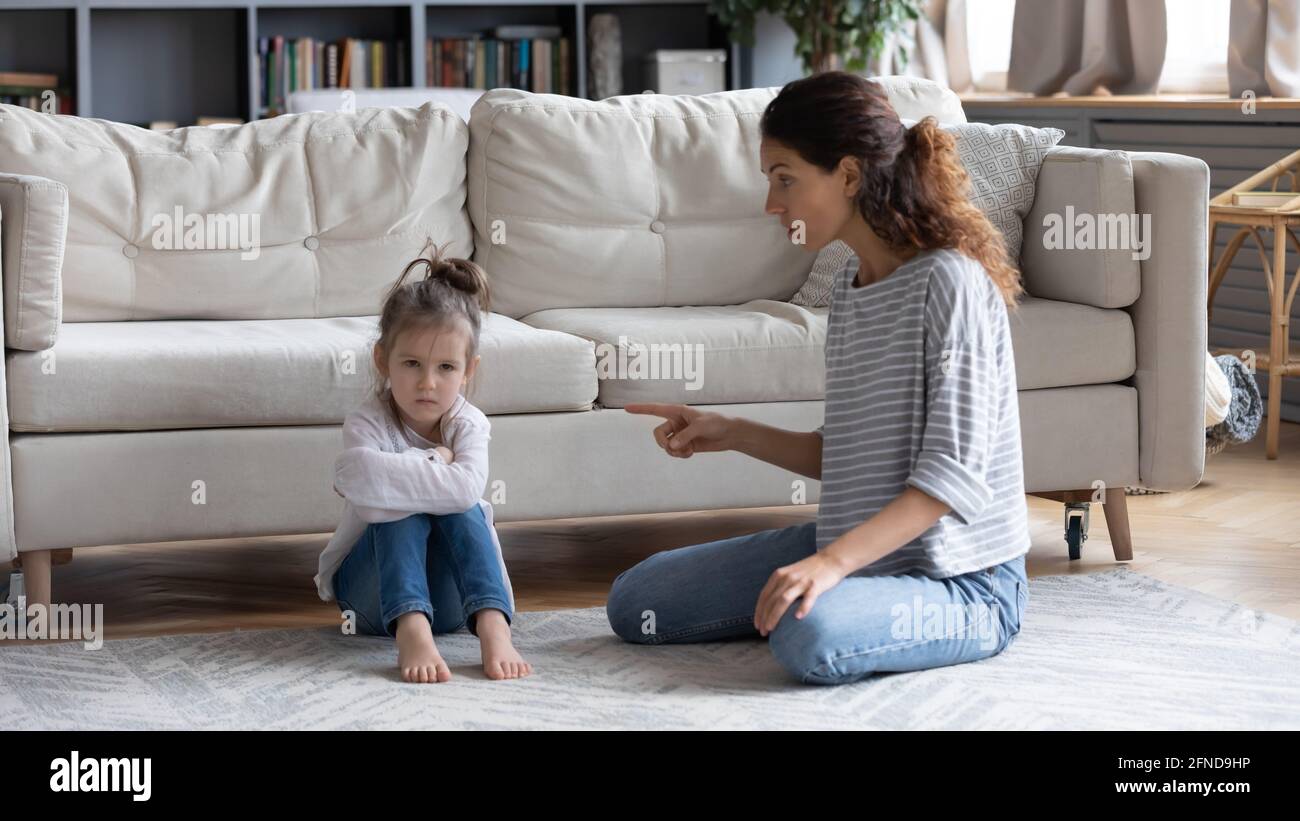 Strict mom scold little daughter at home Stock Photo