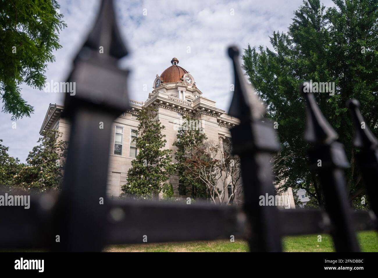 The Lee County Courthouse in Tupelo, Mississippi, USA, framed by the wrought iron fence which