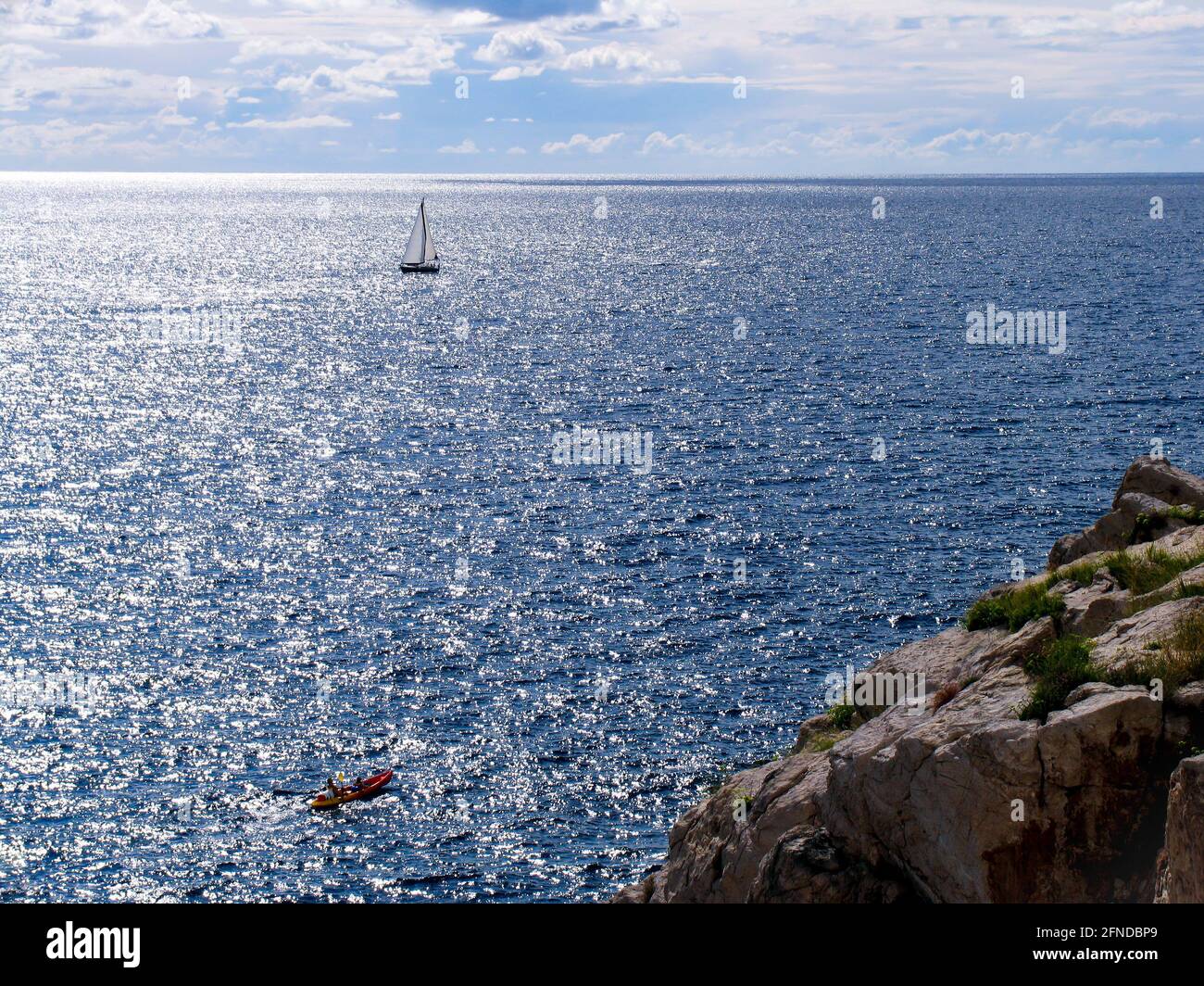 Amazing view of lonely yacht at open sea. Top view from cliff. Stock Photo