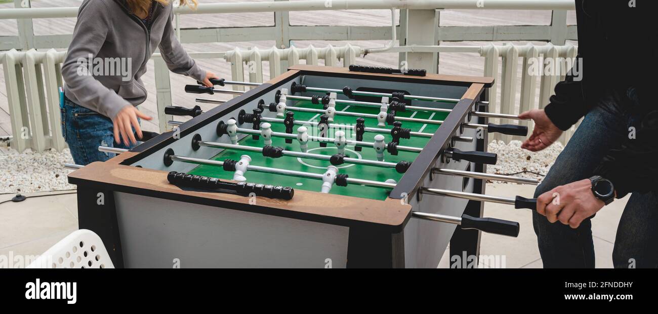 Happy father and daughter in medicine masks playing table soccer in the park Stock Photo