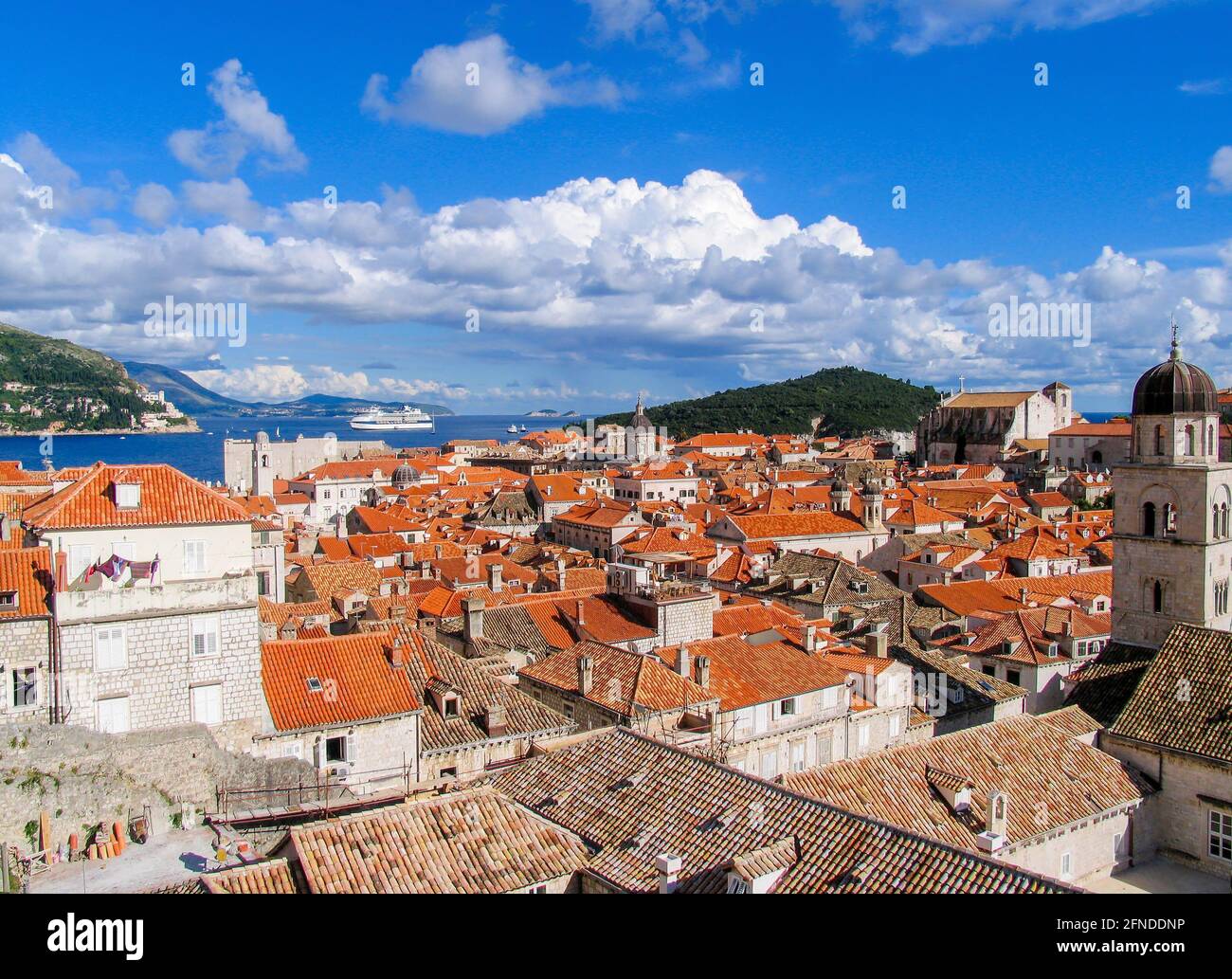 Beautiful view of Dubrovnik old city rooftops, sea and sky with white clouds. Stock Photo