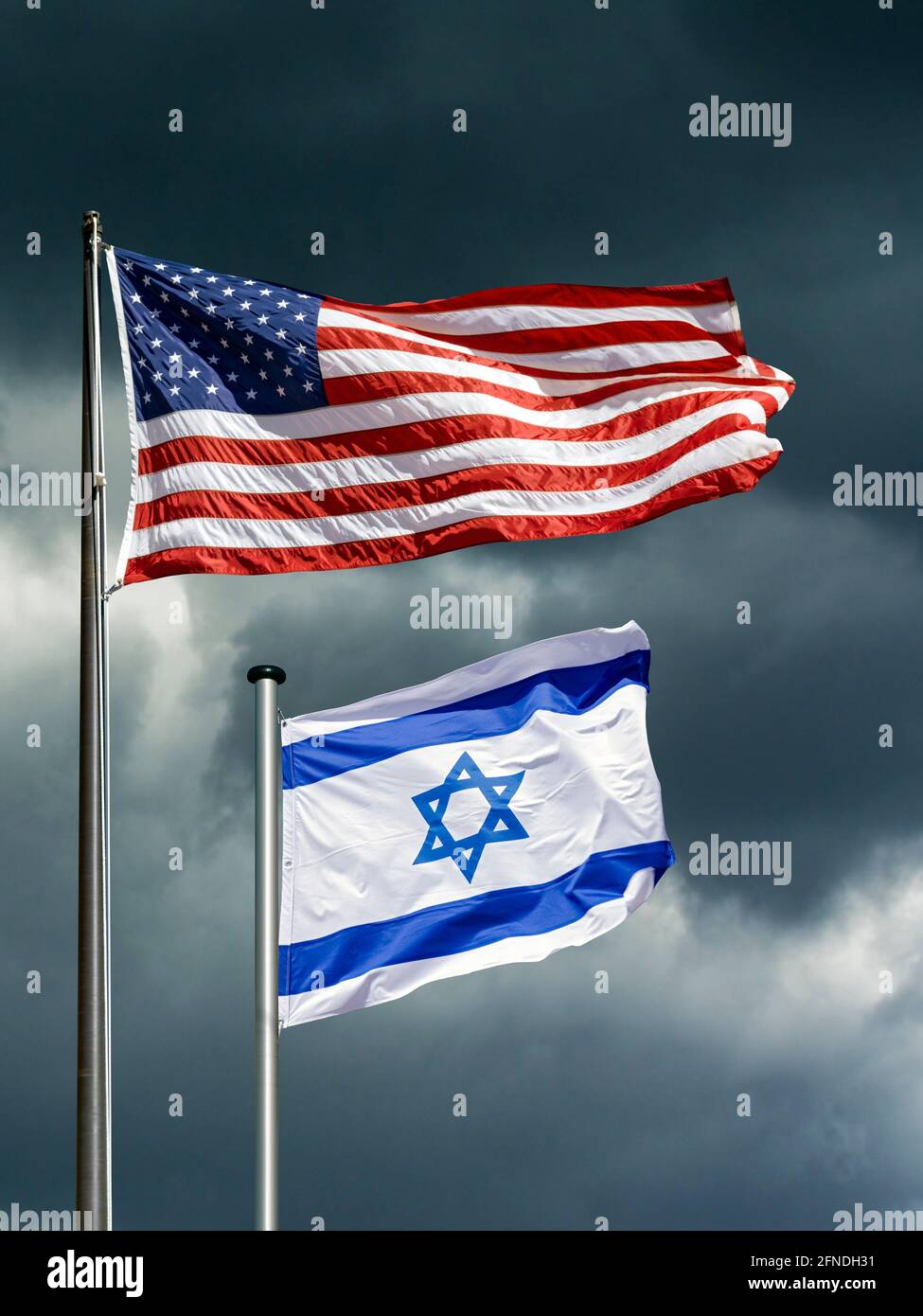 state flags of USA and Israel fluttering in front of a dark, stormy sky ...