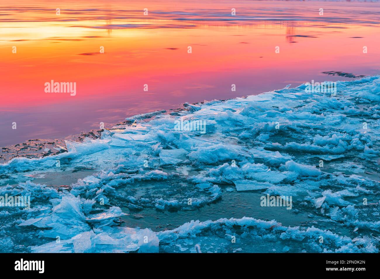 Ice beside river during colorful sunrise Stock Photo