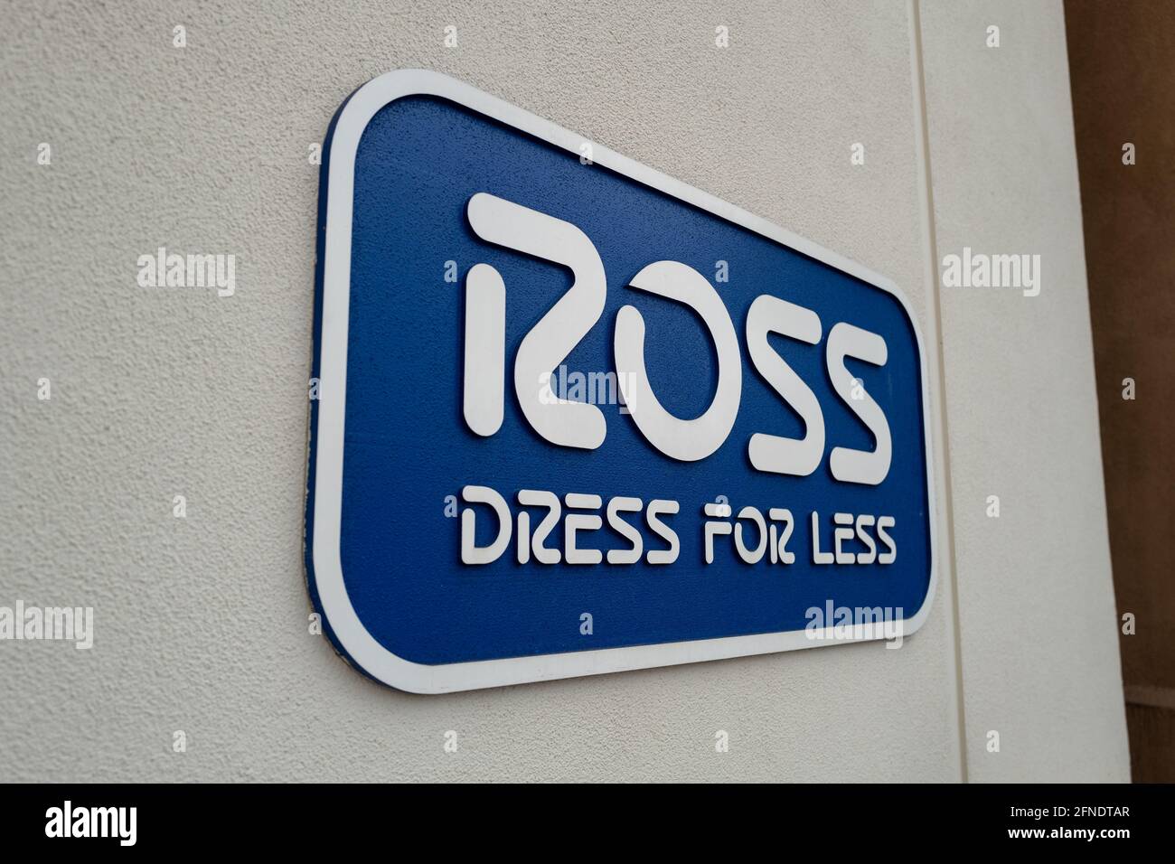 Side view of a sign reading 'Ross Dress for Less' on the facade of Ross