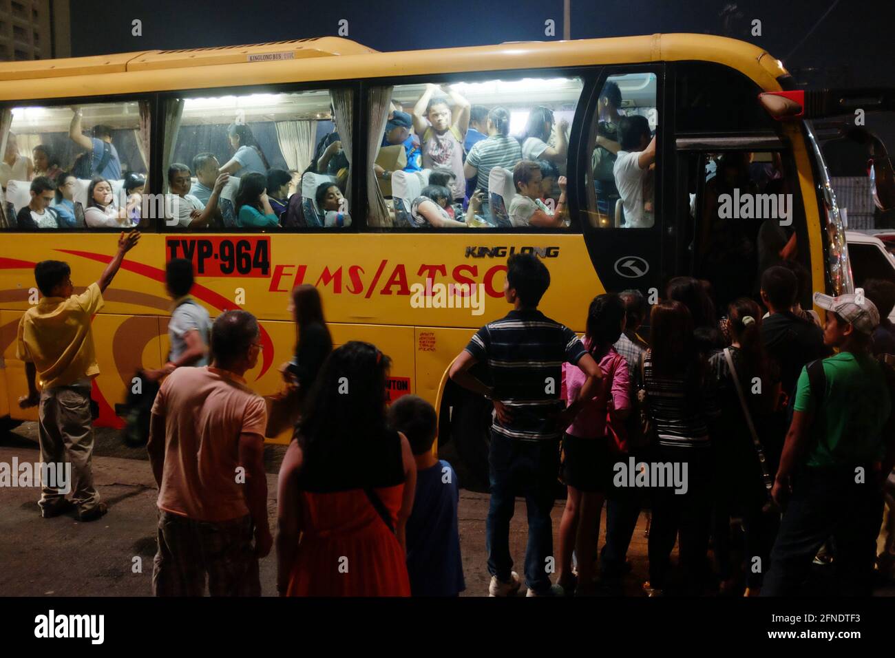 Asian Filipino passengers board an aircon bus at the Mall of Asia bus stop, Metro Manila, Philippines Stock Photo