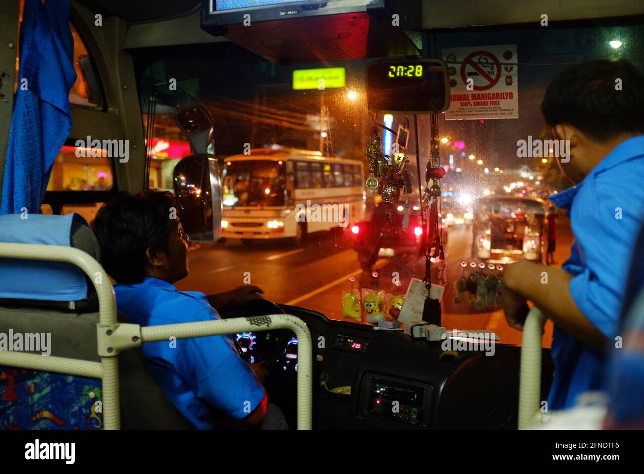 Aircon bus driver talks to a passenger while waiting at the Mall of Asia bus stop, Metro Manila, Philippines Stock Photo
