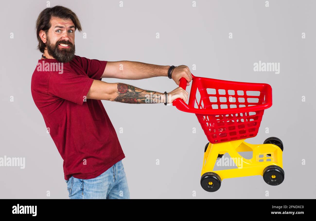 Bearded man with empty shopping cart. Male on shopping. Buying spree. Supermarket. Stock Photo