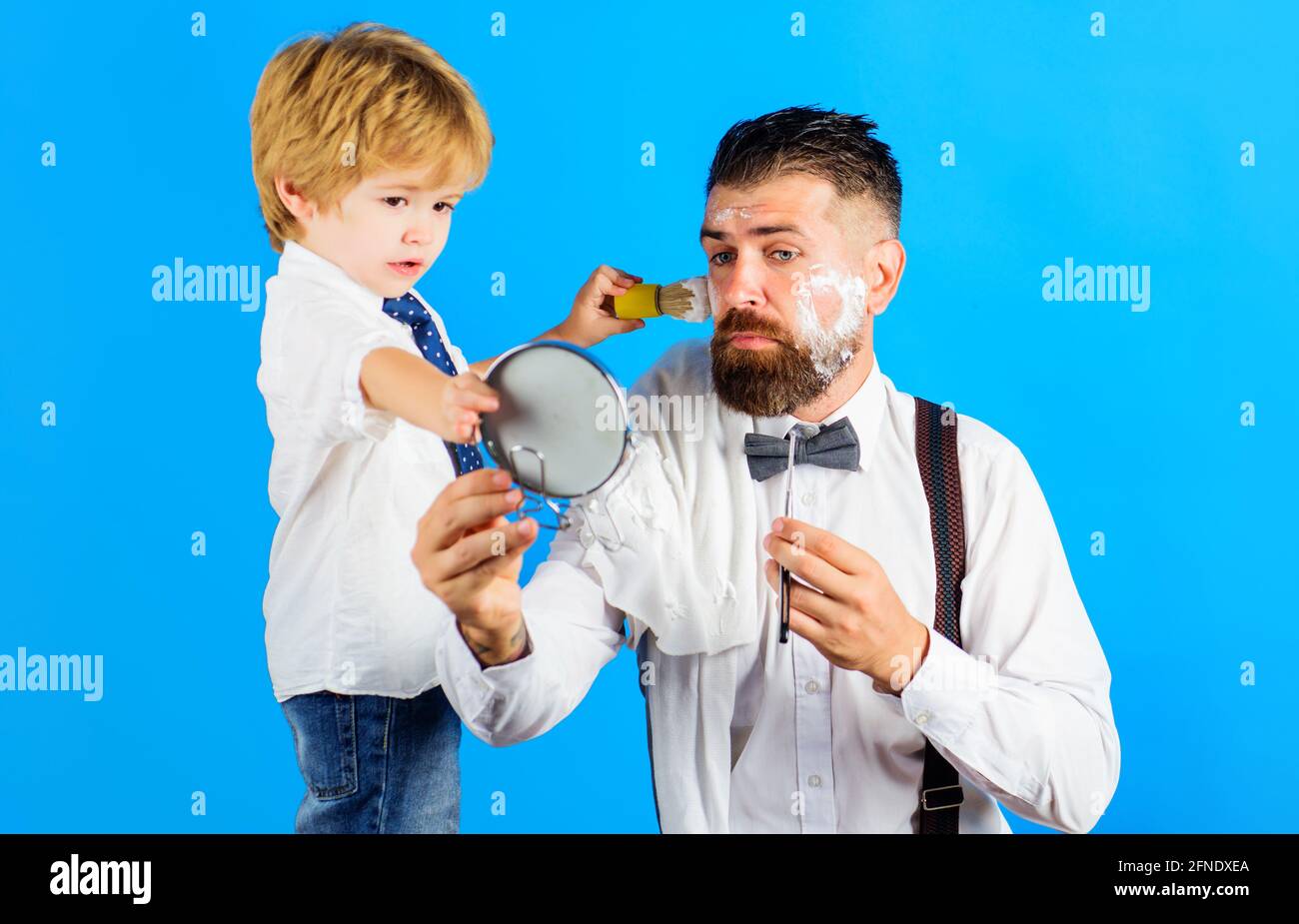 Family time. Fathers day. Son and Father shaving beard. Assistant for dad. Little barber. Barbershop. Stock Photo
