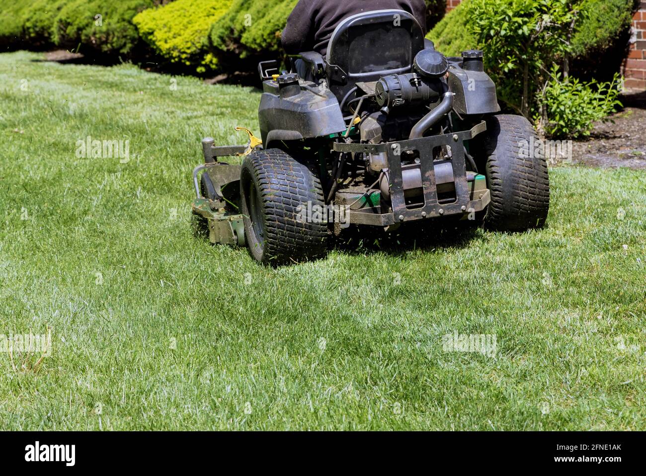 Machine for cutting lawns on lawn mower on green grass in garden. Stock Photo