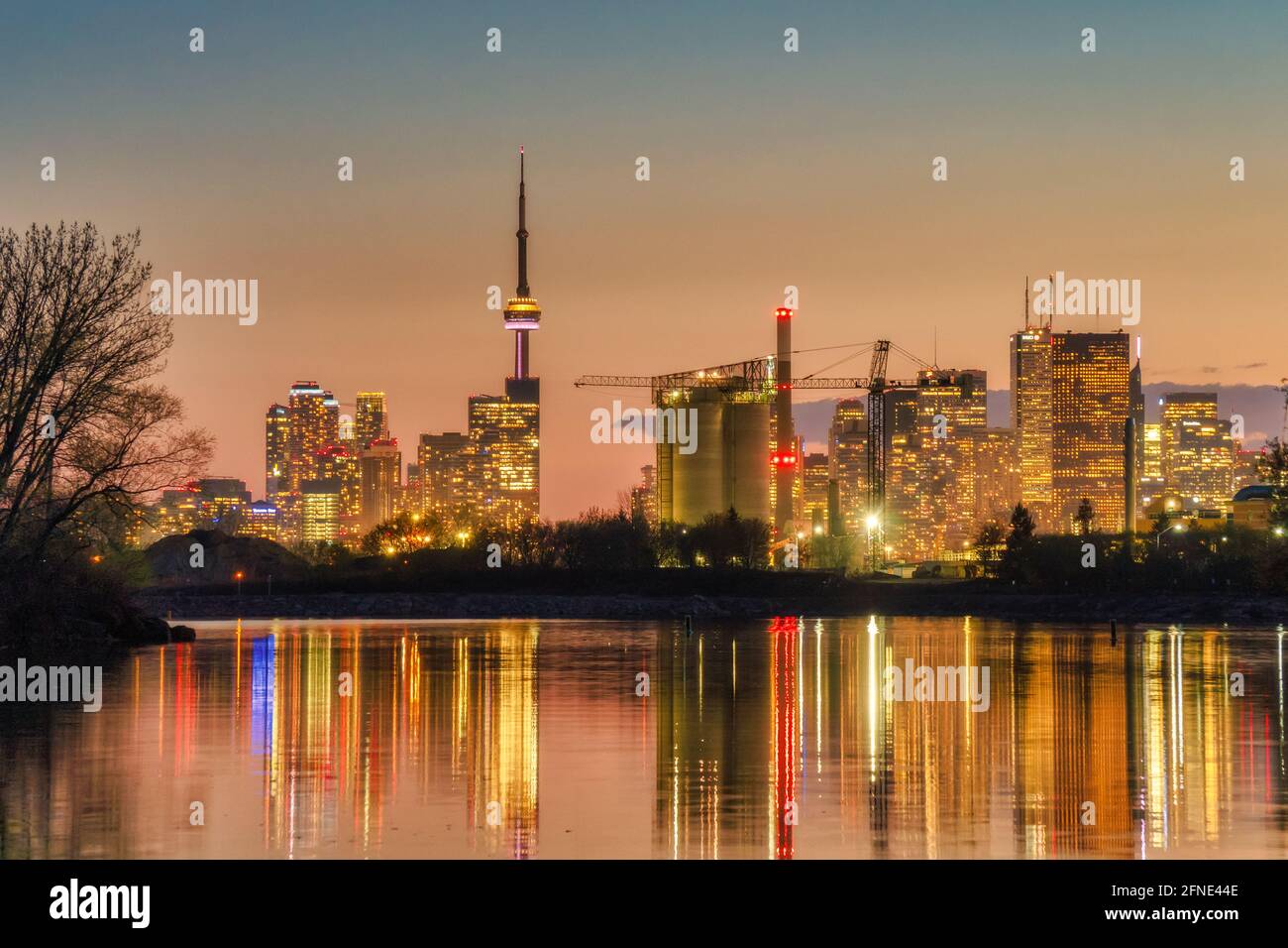Beautiful Toronto waterfront skyline with landmark buildings such as CN Tower in downtown and Hearn Generating Station in Port Lands in golden hour at Stock Photo