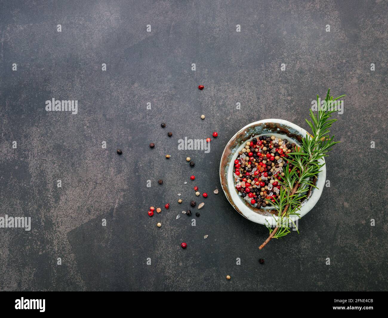 Ingredients for steak seasoning in ceramic bowl set up on dark concrete
