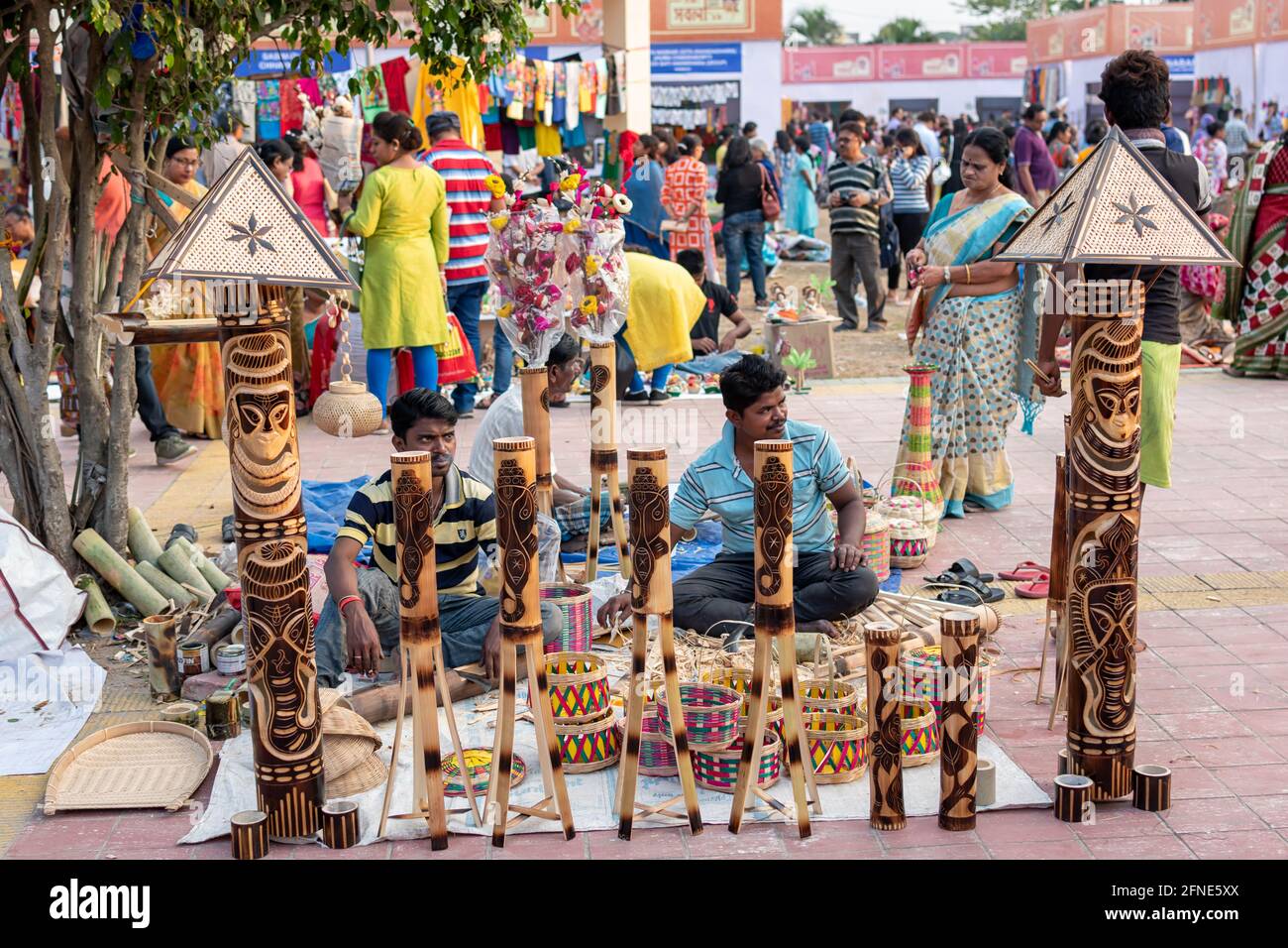 Unidentified men are selling bamboo carving artwork and bamboo sticks items at handicrafts trade fair in Kolkata, West Bengal, India on December 2019. Stock Photo