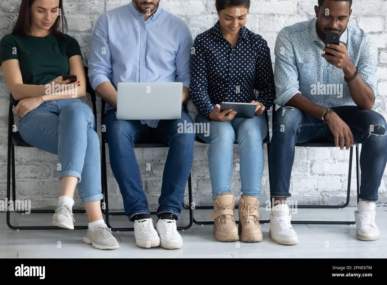 Diverse group of candidates sitting on chairs line Stock Photo