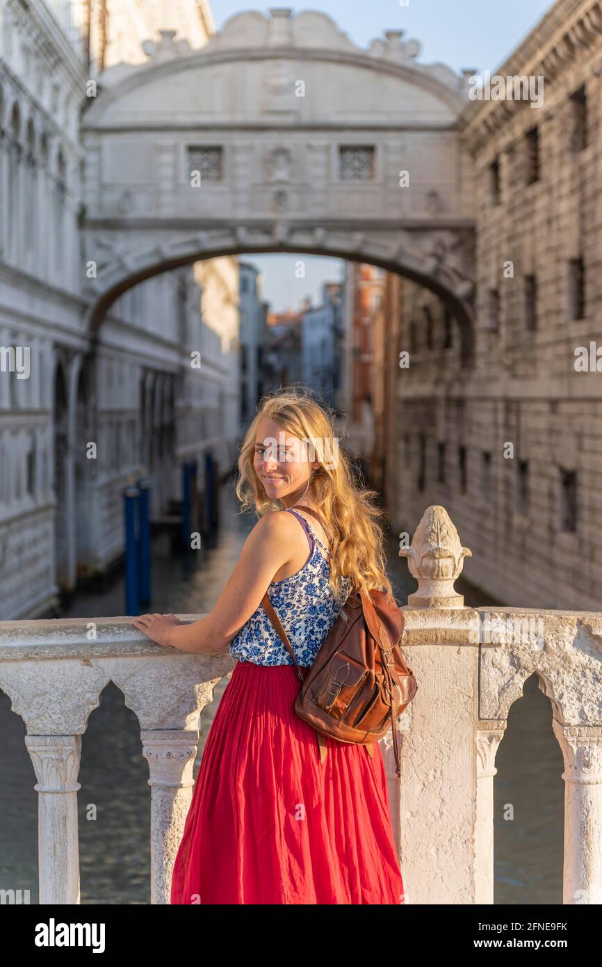 Young woman with red skirt, tourist in front of the Bridge of Sighs, Venice, Veneto, Italy Stock Photo