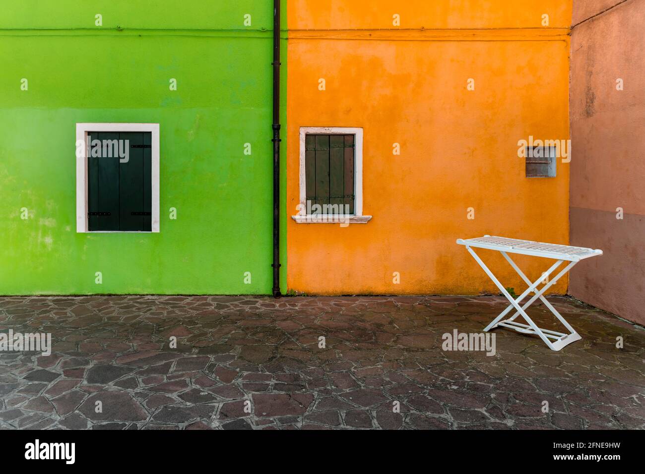 Clothes horse, green and orange wall, colorful house wall,window with closed shutters, colorful facade, Burano Island, Venice, Veneto, Italy Stock Photo