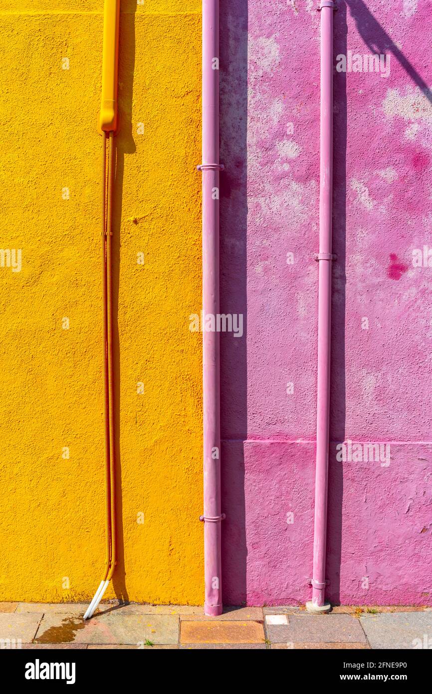 Pink and yellow wall with gutter and cable, colorful house wall, colorful facade, Burano Island, Venice, Veneto, Italy Stock Photo