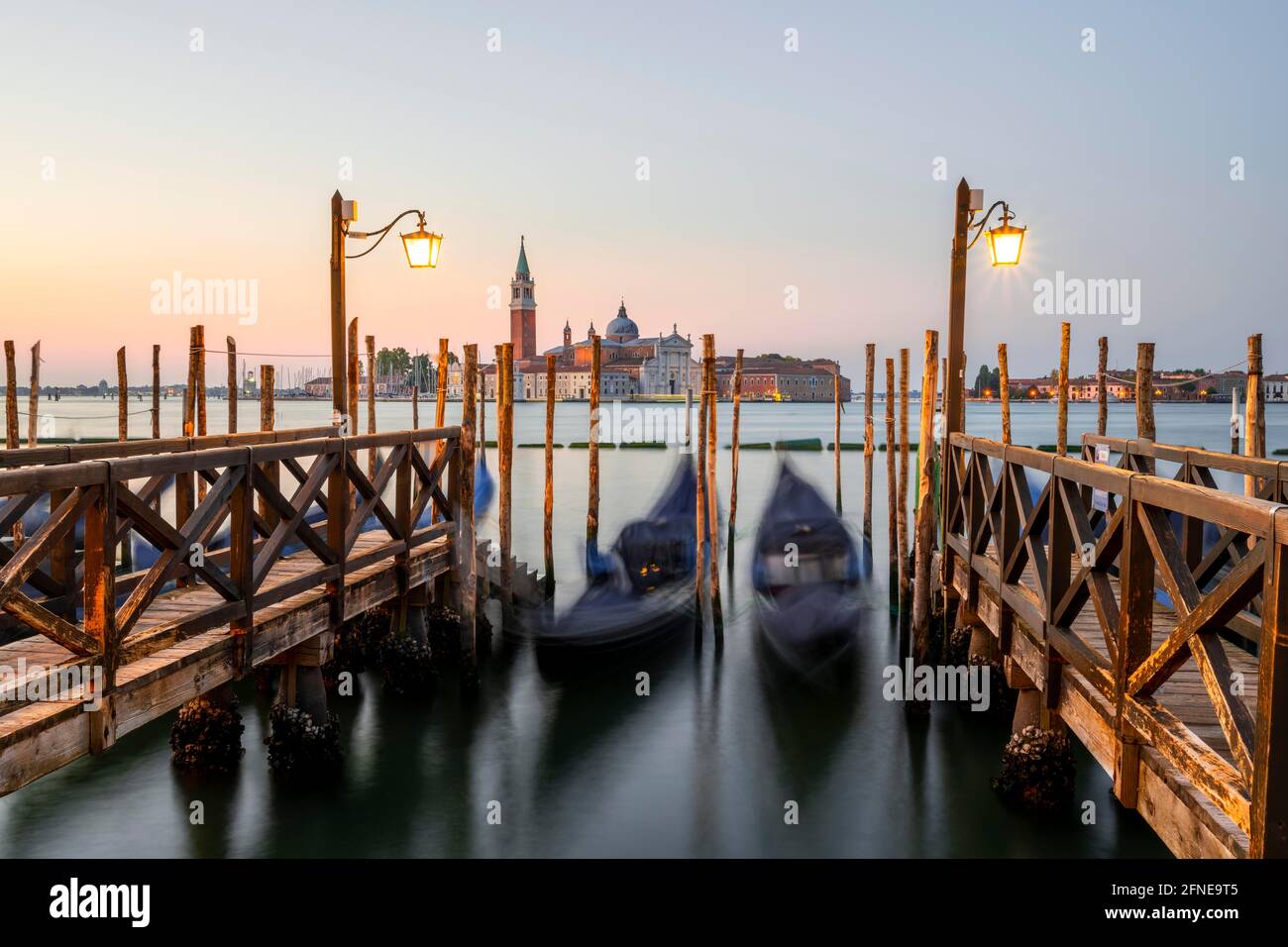 Pier with Venetian gondolas, in the back church San Giorgio Maggiore, long exposure, dawn, Venice, Veneto, Italy Stock Photo