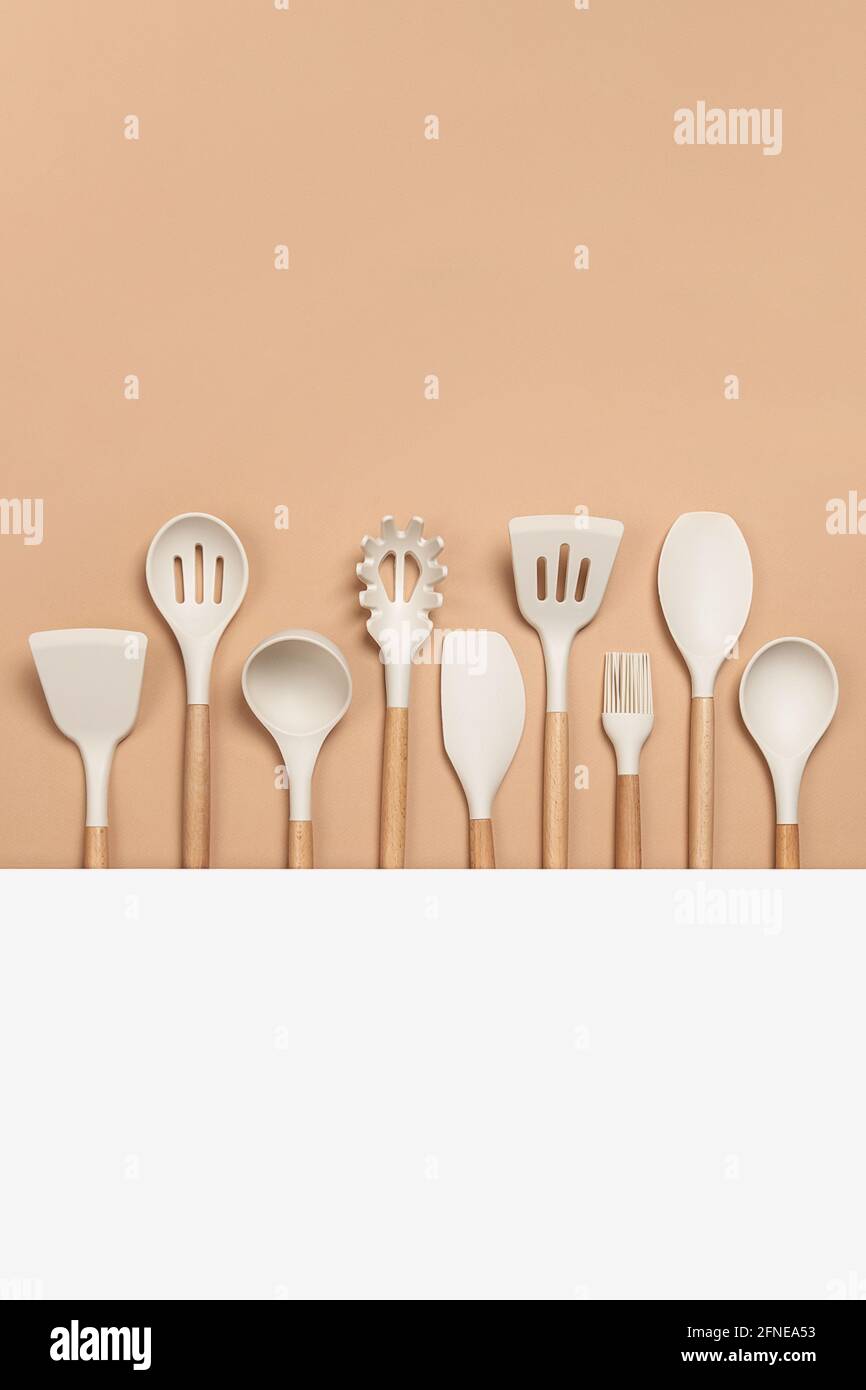 https://c8.alamy.com/comp/2FNEA53/cooking-utensil-set-silicone-kitchen-tools-with-wooden-handle-on-beige-background-with-copy-space-top-view-flat-lay-2FNEA53.jpg