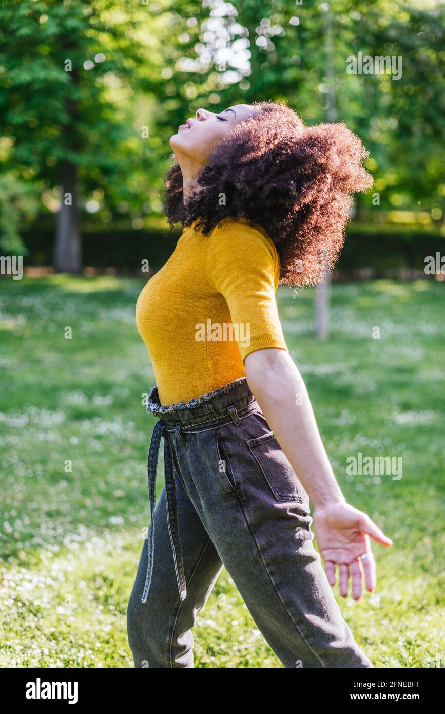Pretty afro woman breathing fresh air in nature, in a garden Stock ...