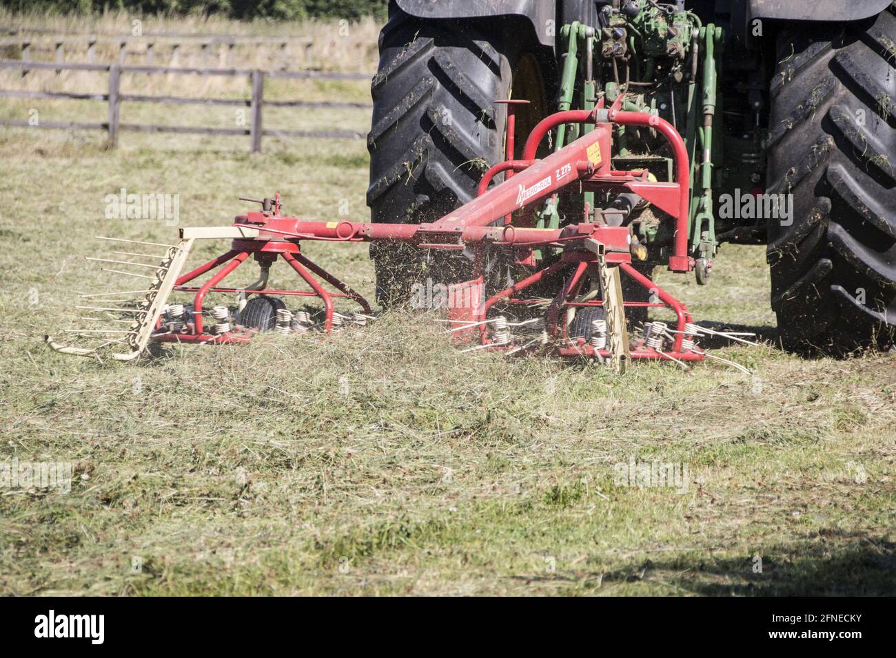 Turning hay, cut grass with tedder Stock Photo Alamy
