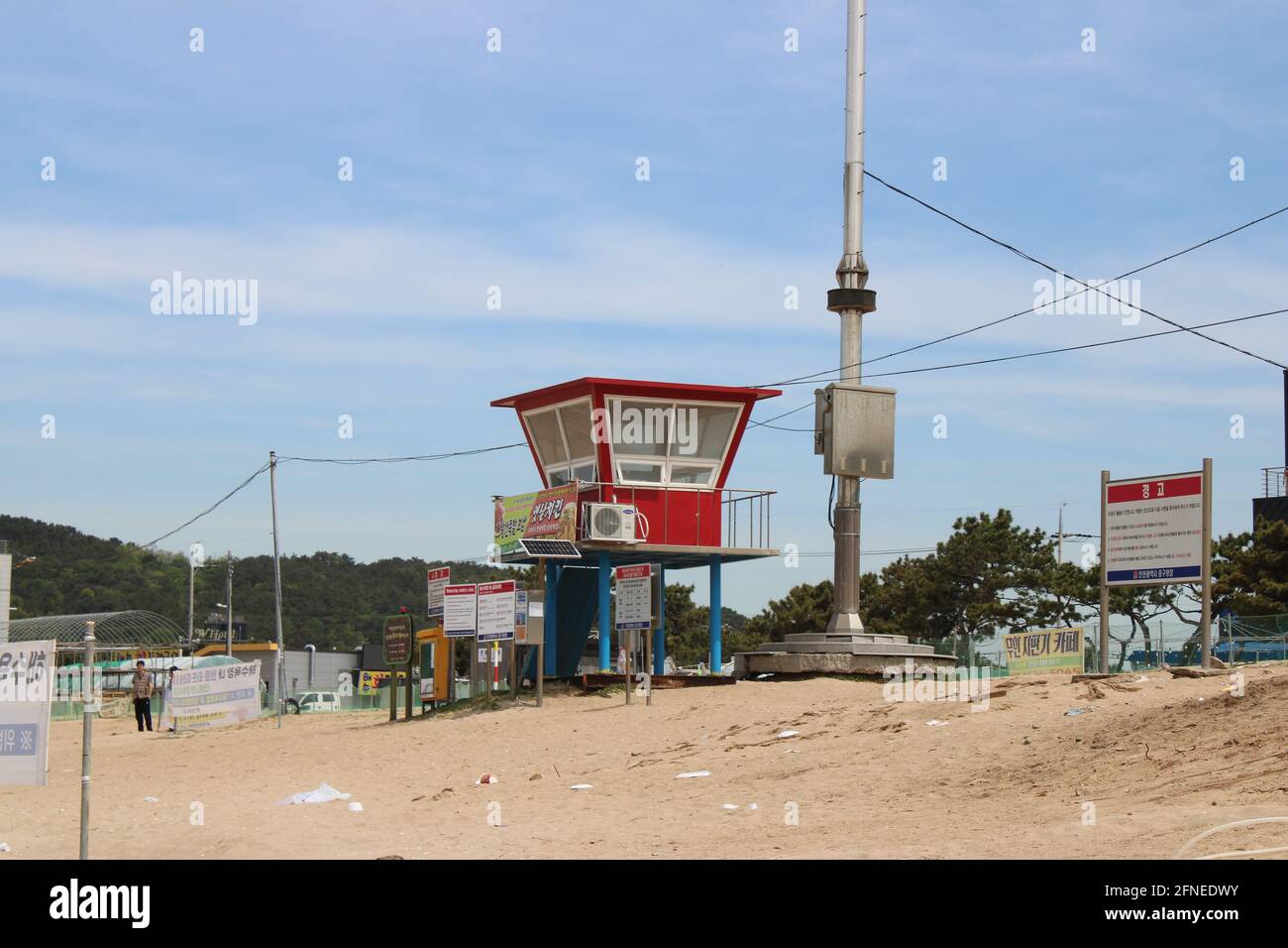 Red lifeguard hut with safety signs and advertisements, on Wangsan Beach, in Incheon, Korea Stock Photo