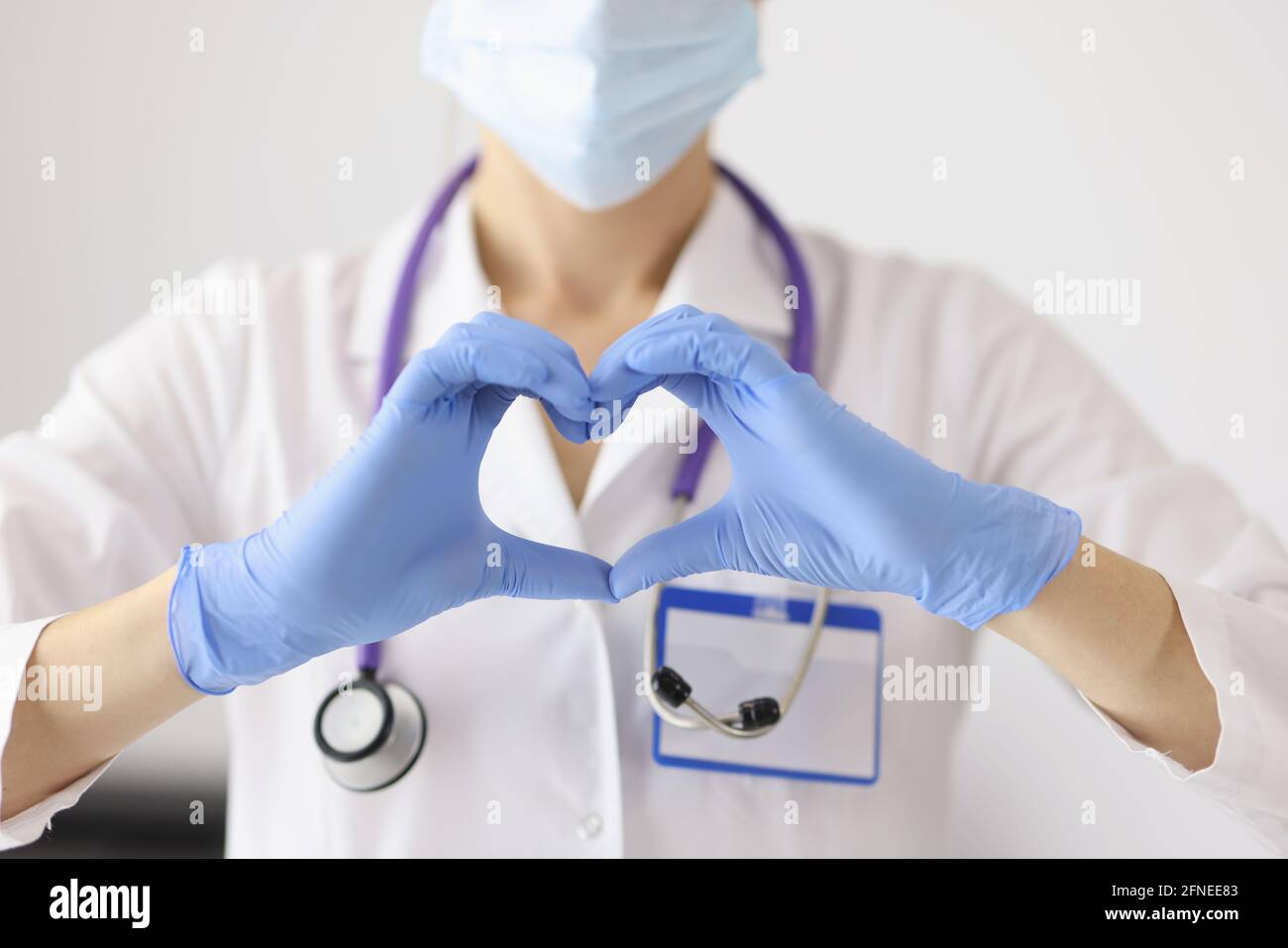 Doctor in protective medical mask shows heart with his hands Stock ...