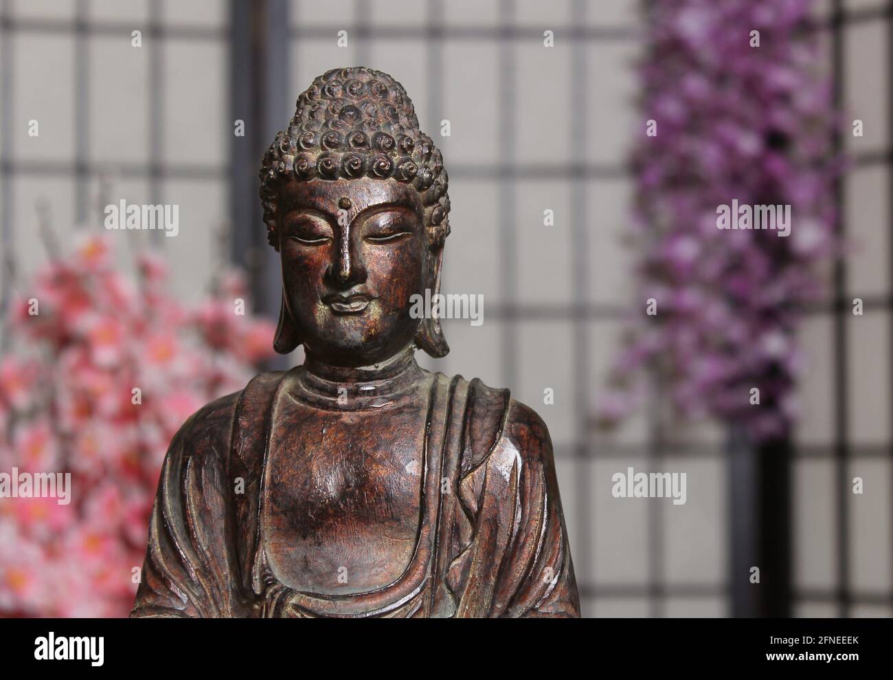 Buddha Statue in Asian Style Room With Cherry Blossoms in Background Indoors Stock Photo
