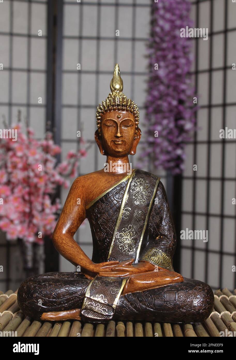 Buddha Statue in Asian Style Room With Cherry Blossoms in Background Indoors Stock Photo