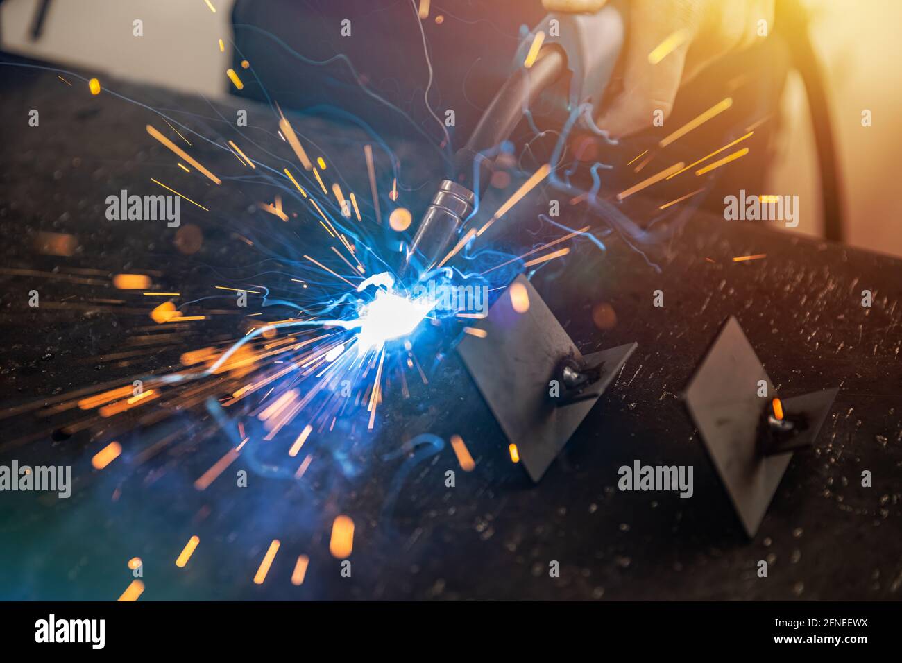 Industry worker welding iron pieces at work. Metalwork manufacturing and construction maintenance service Stock Photo