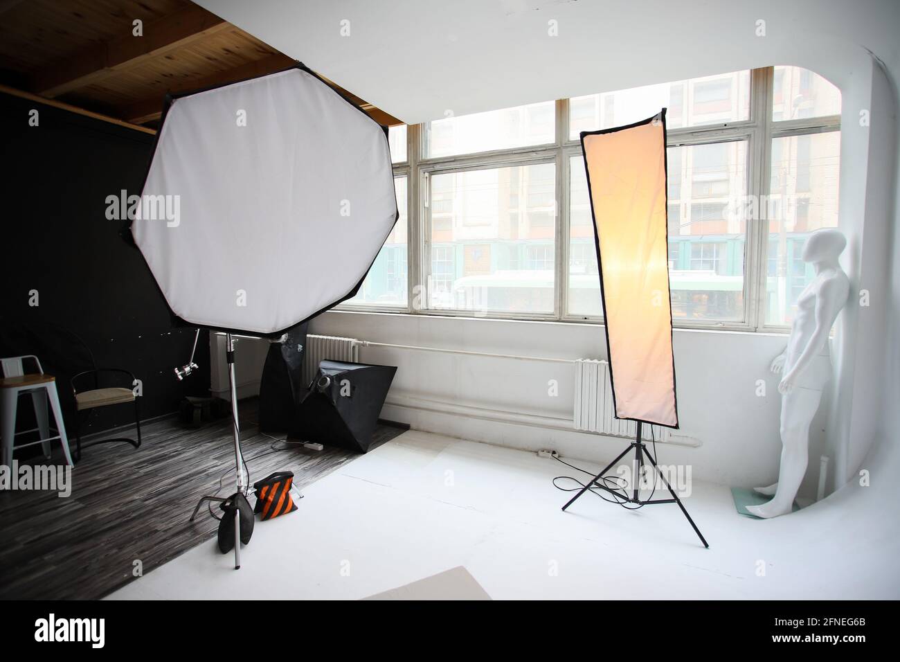 Orthobox and strip lights in a professional photo studio. Photo studio,  lighting fixtures, white endless background, white cubes. Professional  studio equipment. Photo studio, lighting fixtures, white endless  background, white cubes. A professional