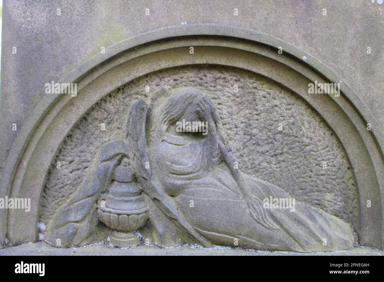 Stone arch with a carving of a female figure grieving. Part of a  set of 4 images Stock Photo