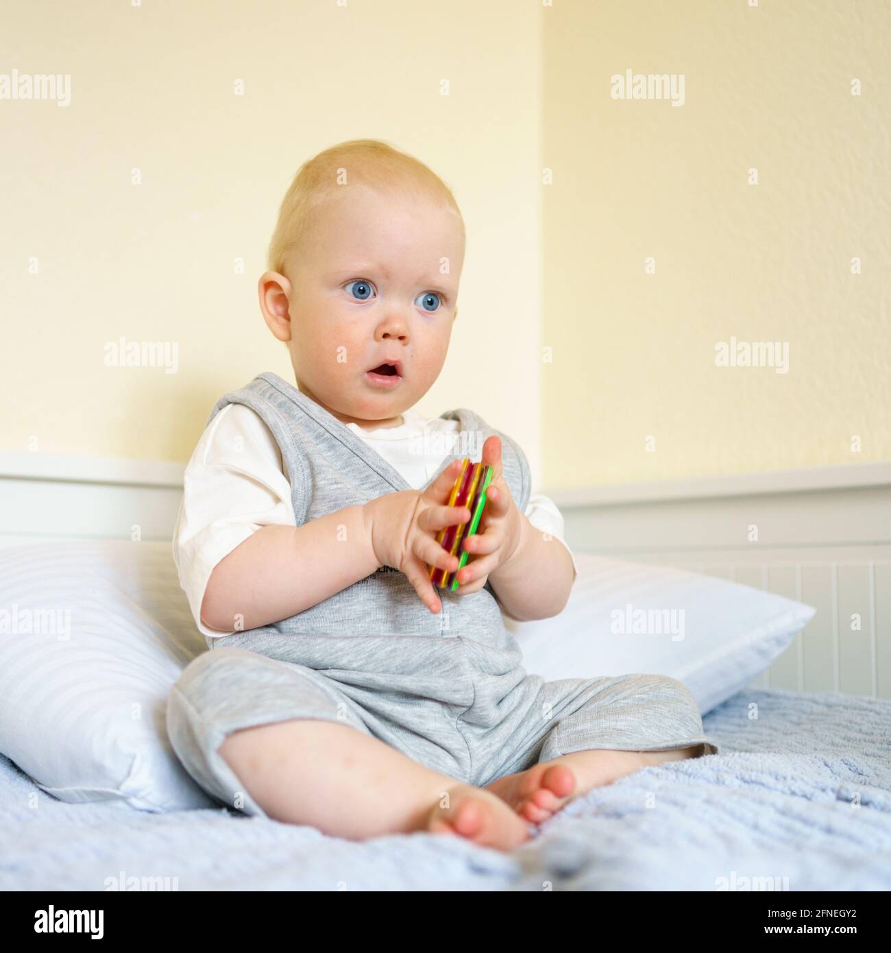 Curious baby boy sitting on bed hi-res stock photography and images - Alamy