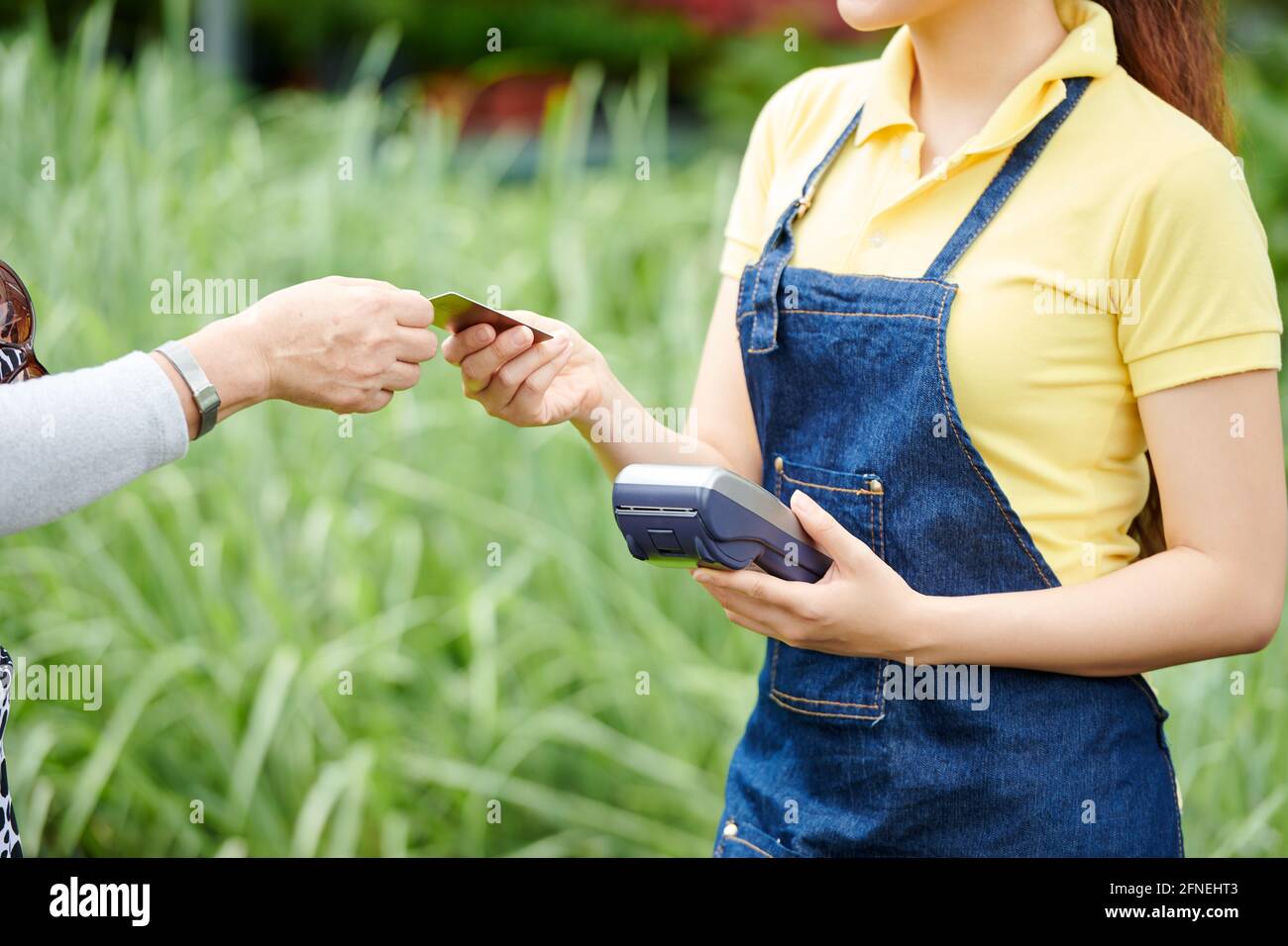 Hands of gardening center worker accepting payment from customer with credit card Stock Photo