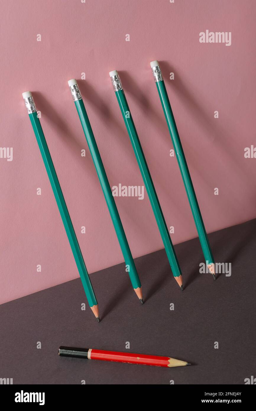 Geometric minimalistic composition with wooden pencils. New matching green  pencils are leaning against a pink wall. An old red with black pencil lies  Stock Photo - Alamy