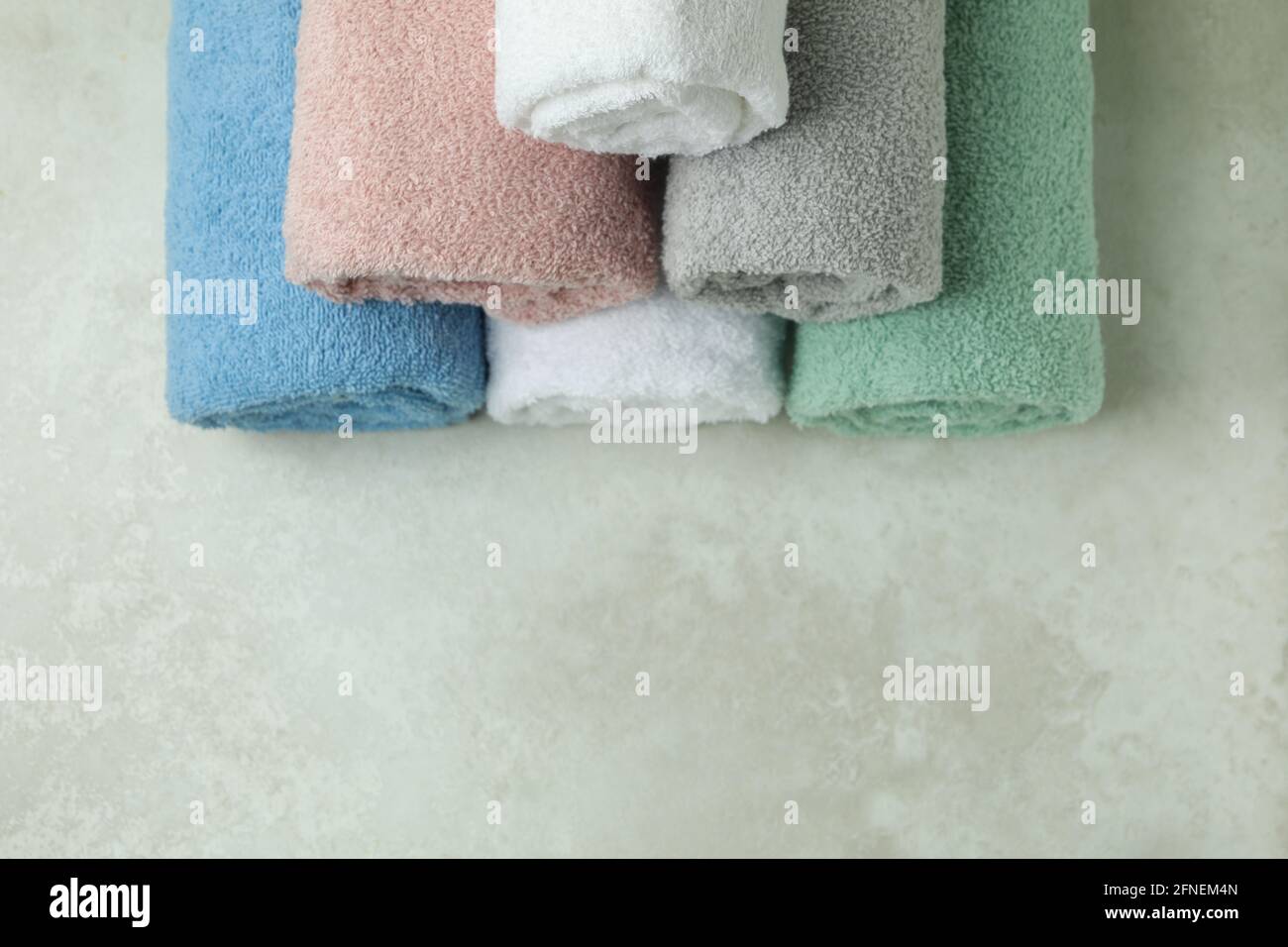 Clean rolled towels on textured background, space for text Stock Photo