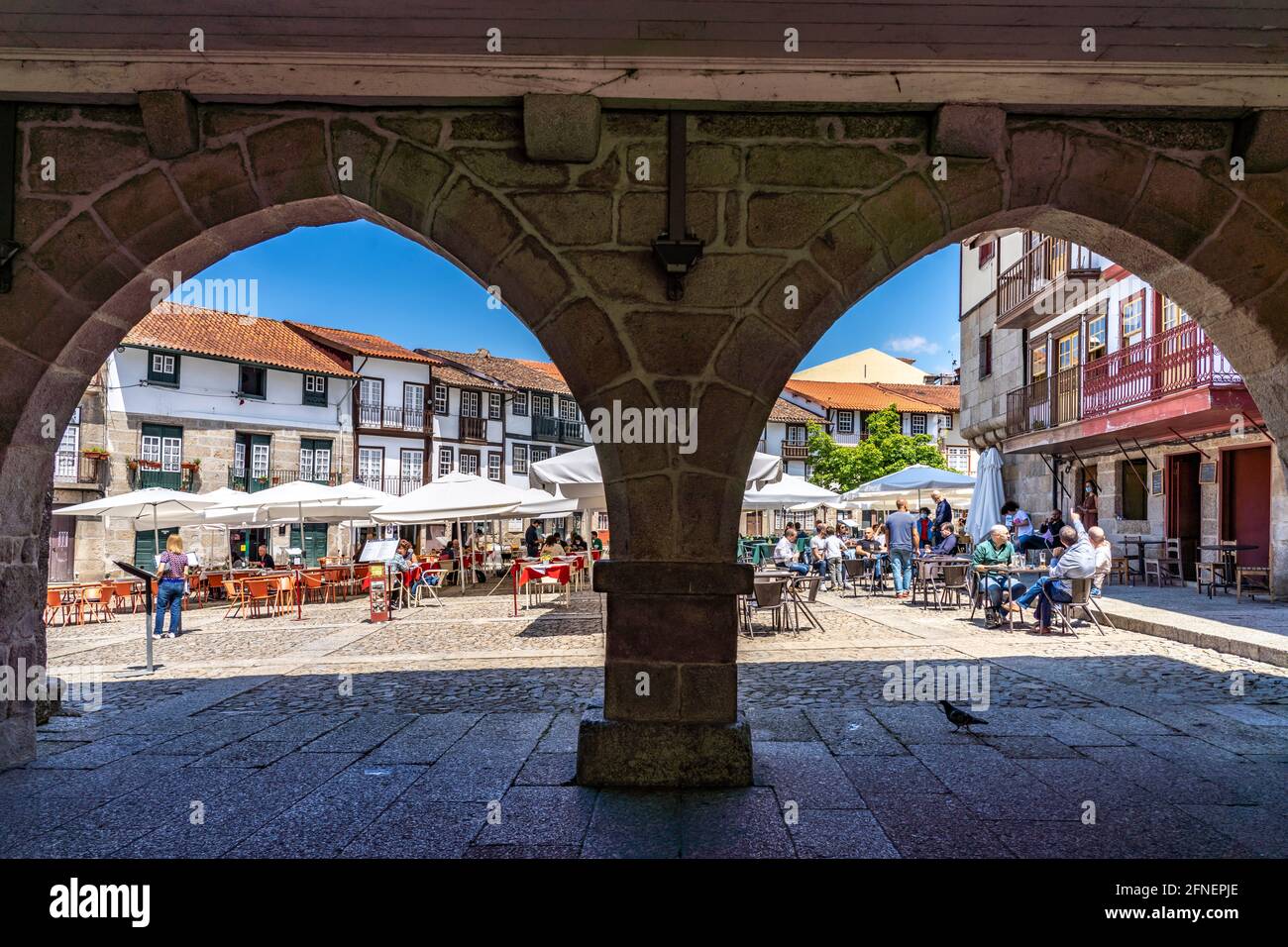Restaurants am  Platz Praça de São Tiago und die Säulen des ehemaligen Rathaus in der Altstadt von Guimaraes, Portugal, Europa   |  Praça de São Tiago Stock Photo