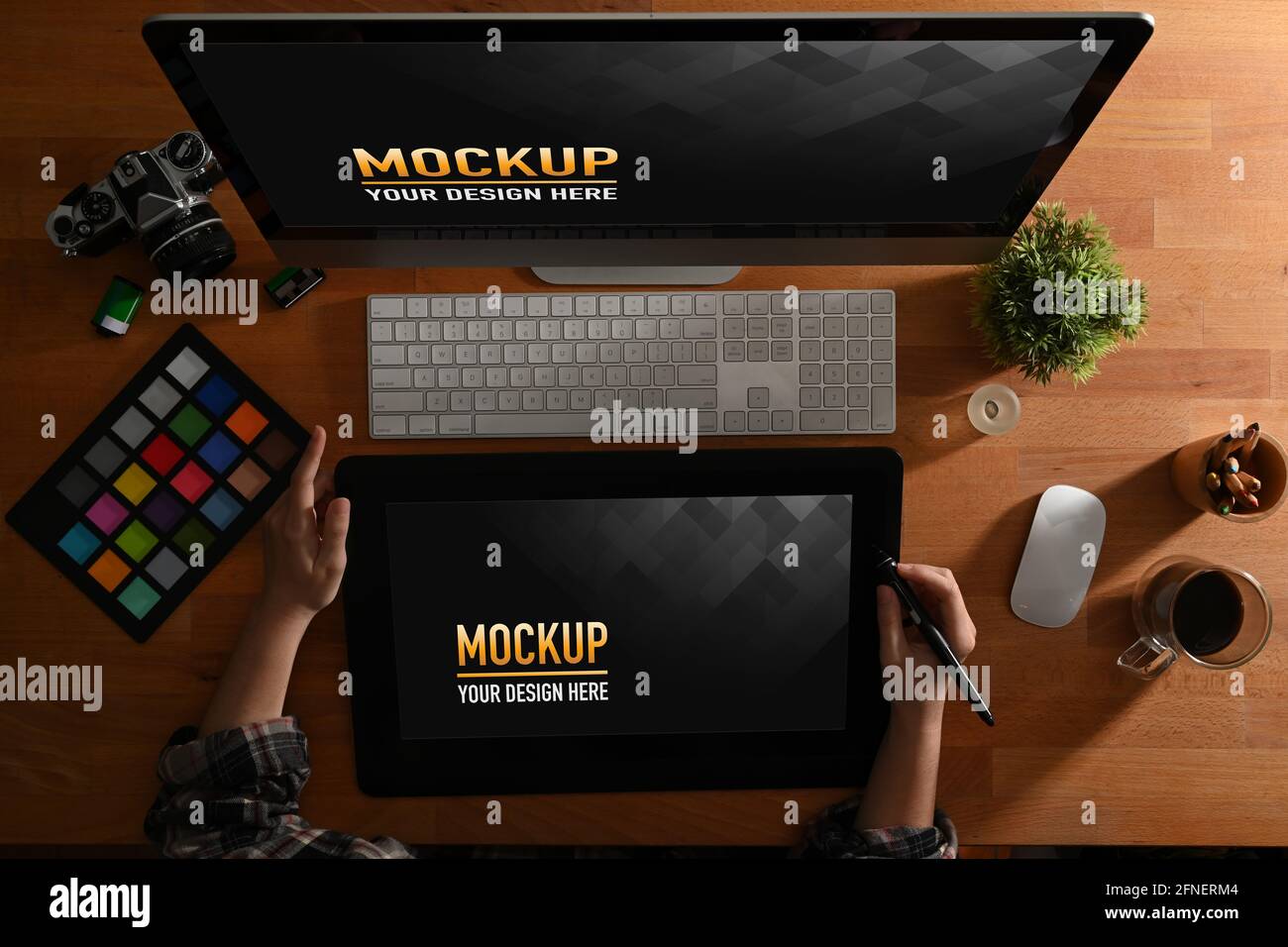 Top view of female graphic designer hands using drawing tablet, computer and supplies on wooden table Stock Photo