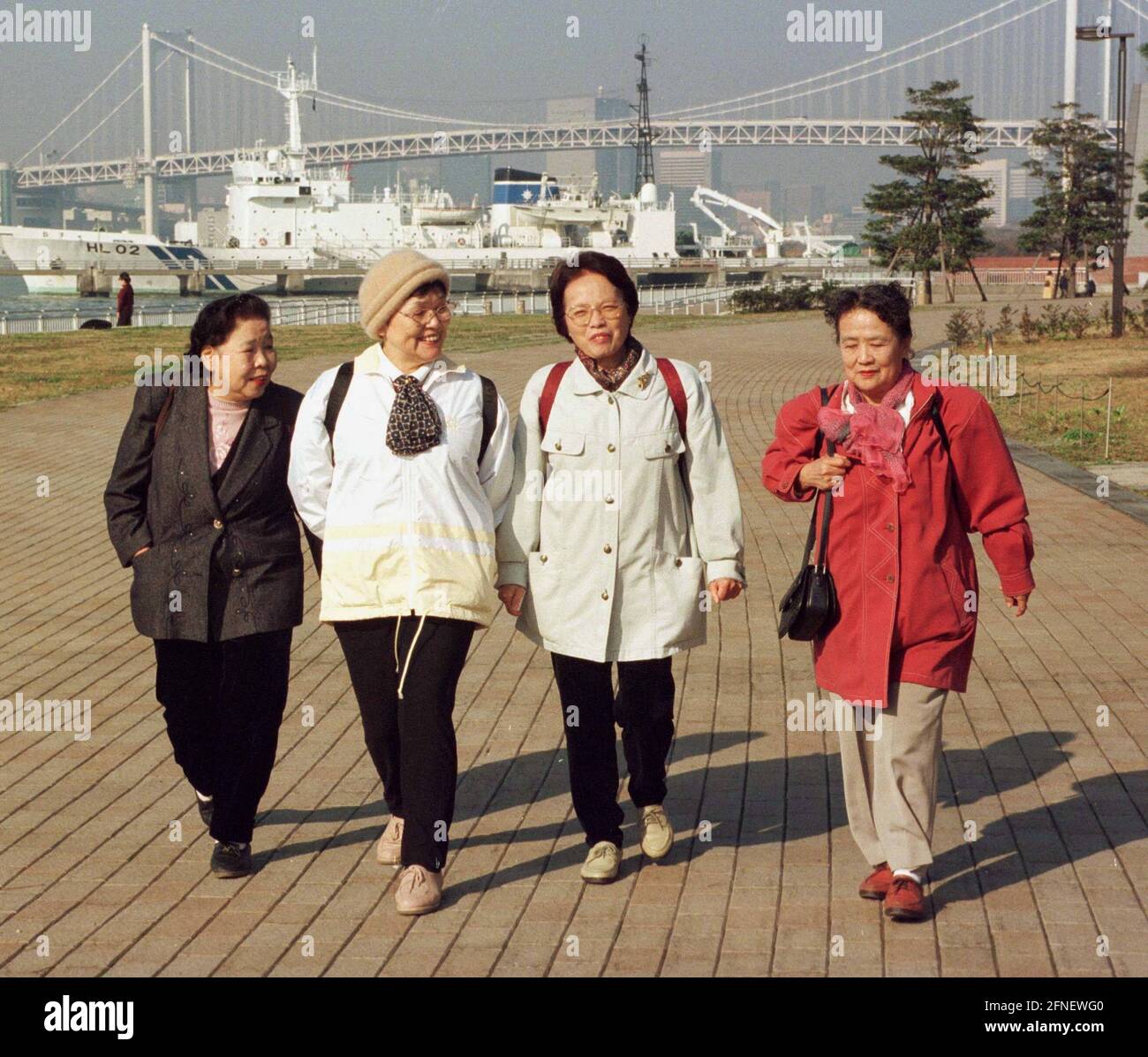 Four women on the road on Daiba. This artificial island off the capital is a new district of Tokyo. [automated translation] Stock Photo