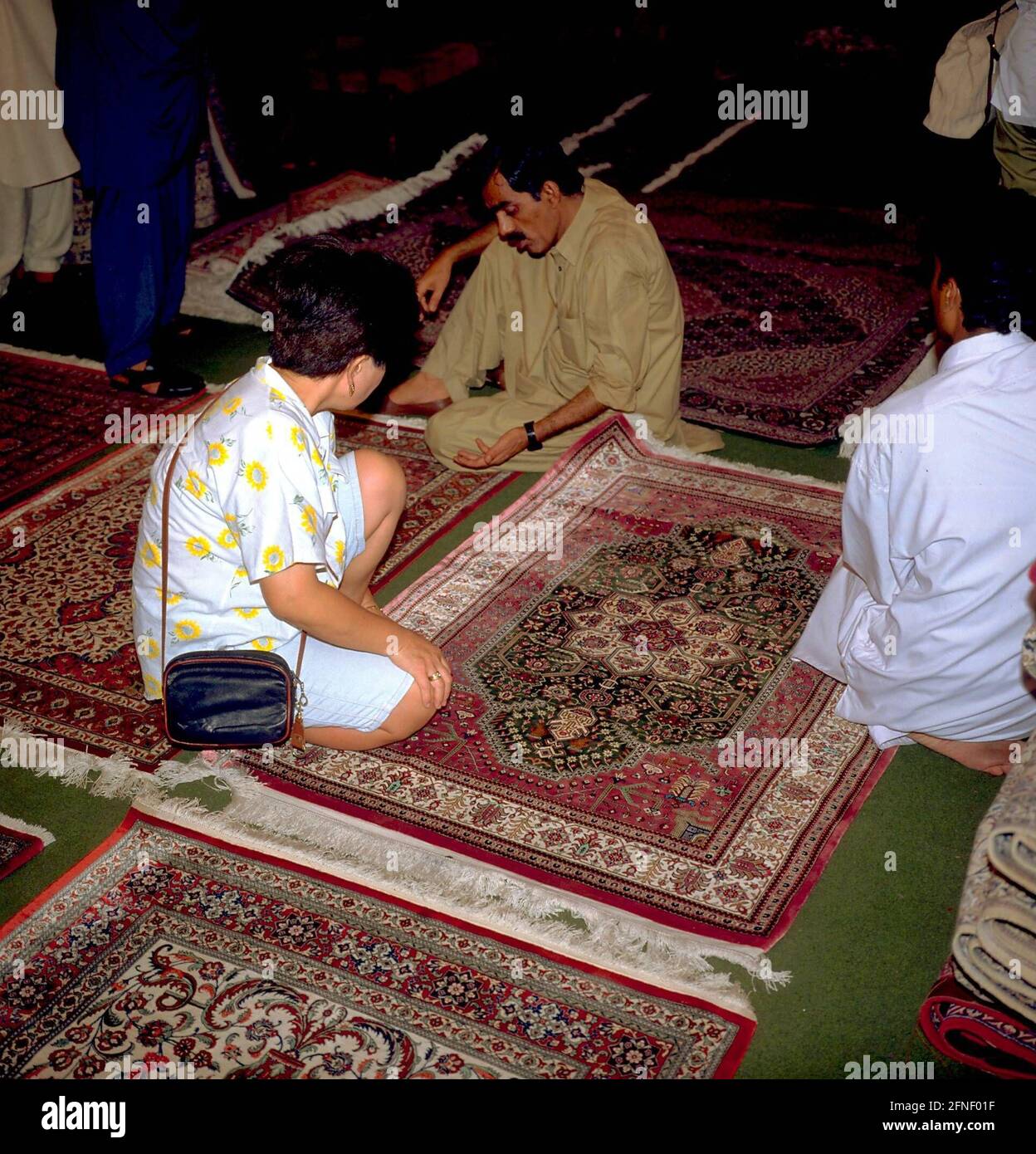 Tourists buying carpets at a shop in Karachi. [automated translation