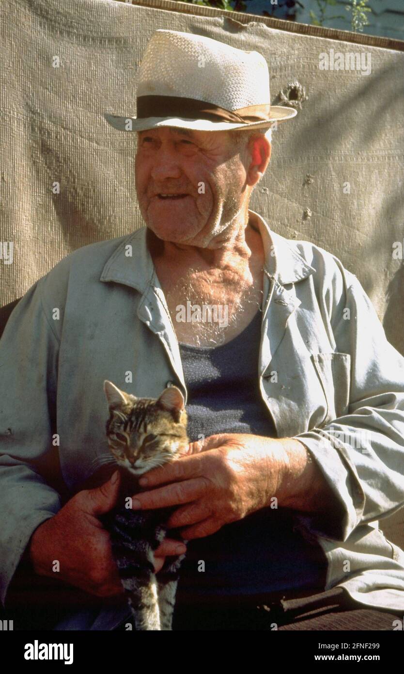 Old man with cat in the German rayon Asowo near the West Siberian Omsk. In Siberia, settlements of Russian Germans (Siberian Germans) were established from 1881 onwards. [automated translation] Stock Photo