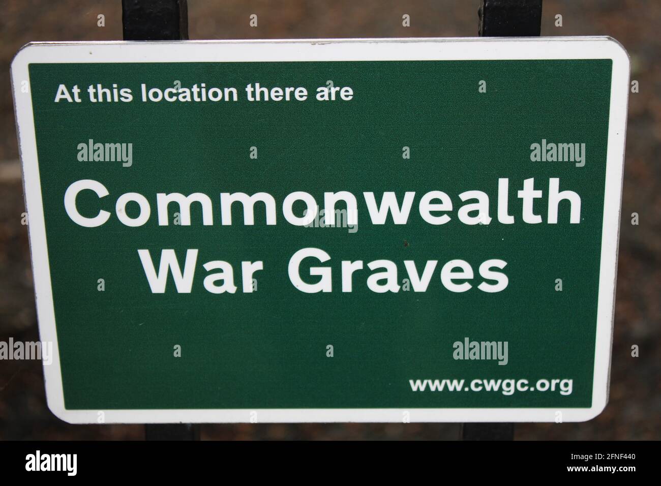 Commonwealth war graves sign advises that a cemetery is the location of the graves of service men and women managed by the commonwealth war graves com Stock Photo